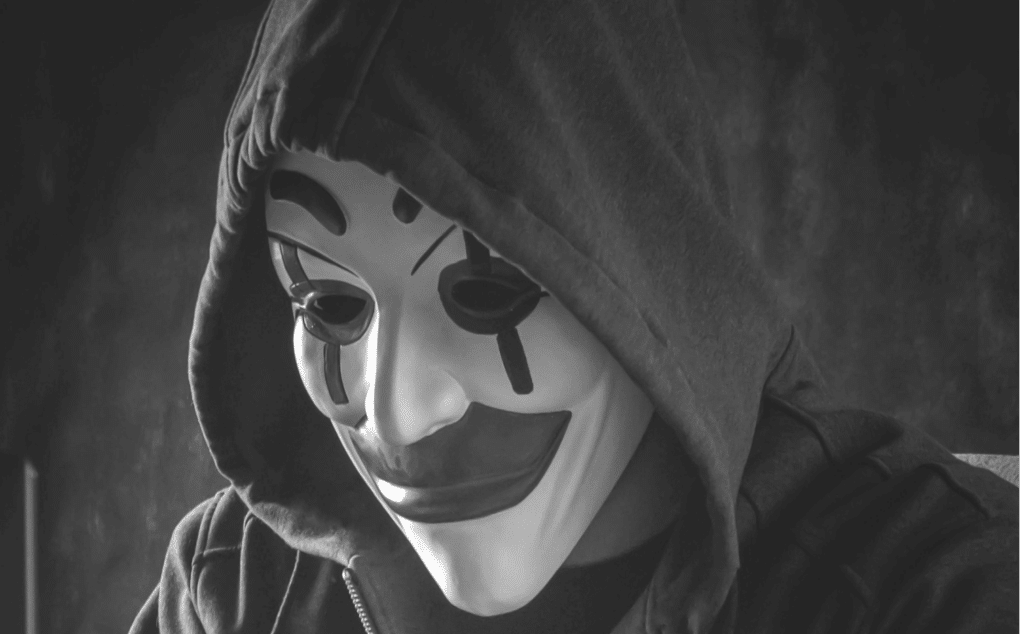 Here we have an image of a hooded, masked actor, illustrating the cyberthreats and impostors attacking the investing industry, and the need to unmask them to make digital spaces safe.