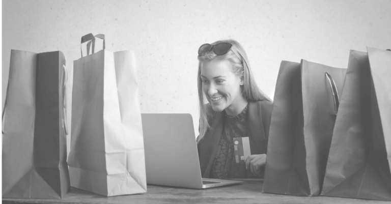 This thumbnail encapsulates the blog's topic of fake online shopping websites, depicting a happy woman using a computer while surrounded by shopping bags.