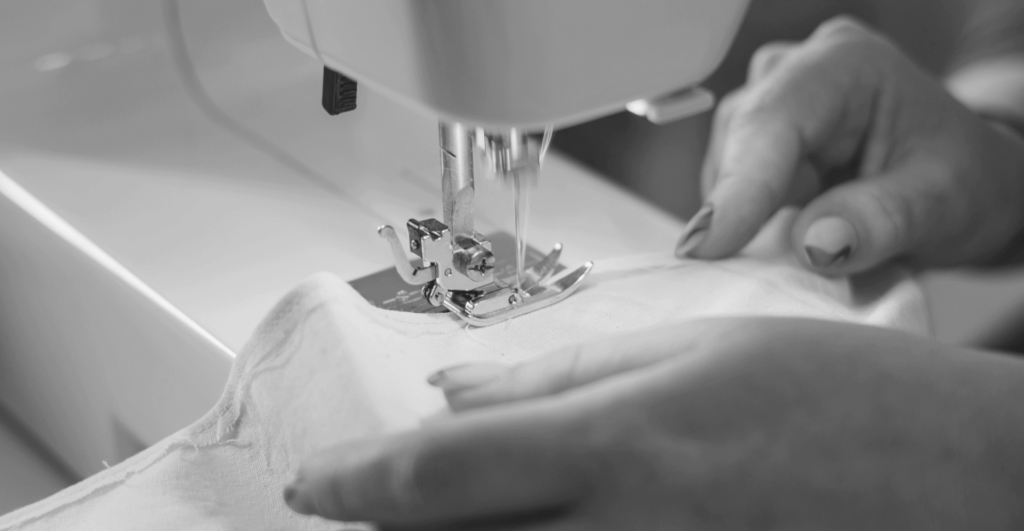 Here we have the first main image to illustrate superfine luxuries: a black and white close-up of someone sewing fabric.