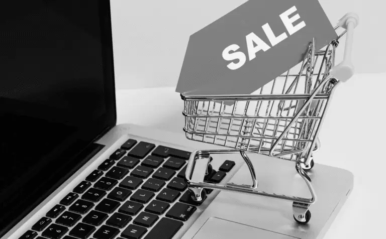 This image of a shopping cart with a sales sign on a laptop highlights the opportunities and scams available on Singles Day.