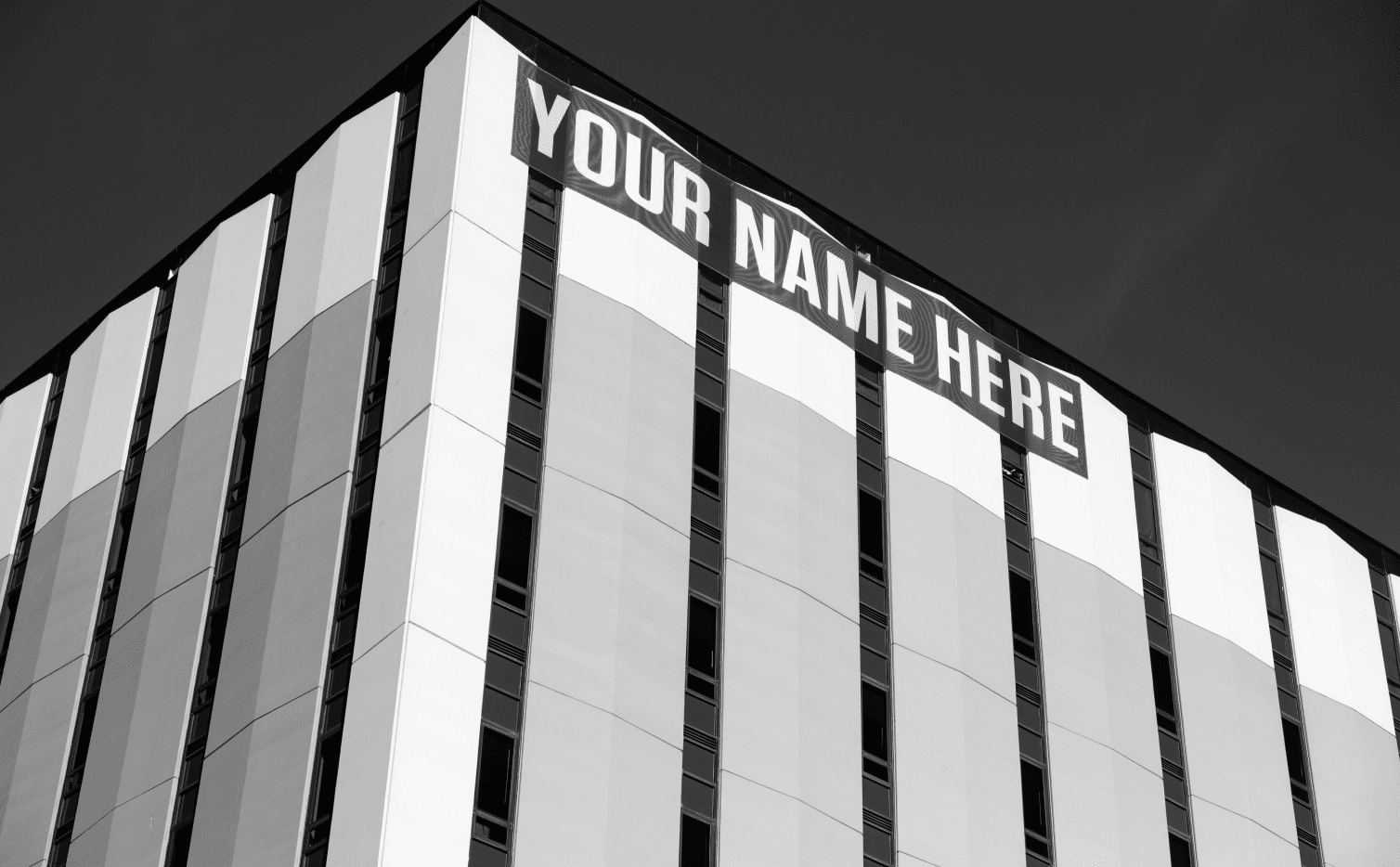 This image of a building bearing the words "Your name here" highlights the topic of this piece's cybersecurity discussion: Domain name protection.