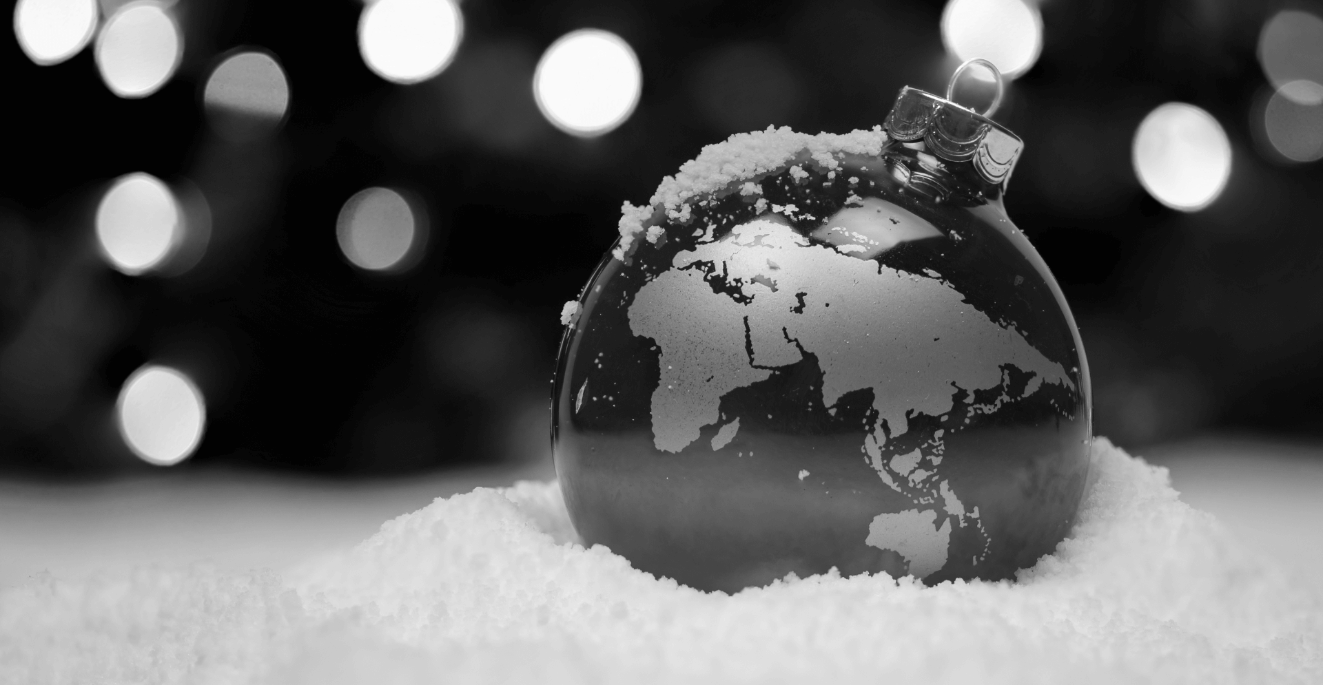 This image of a bauble in the snow with a stencil of a globe on it highlights this article's main topic: global issues at Christmas, specifically the international impact of counterfeits.