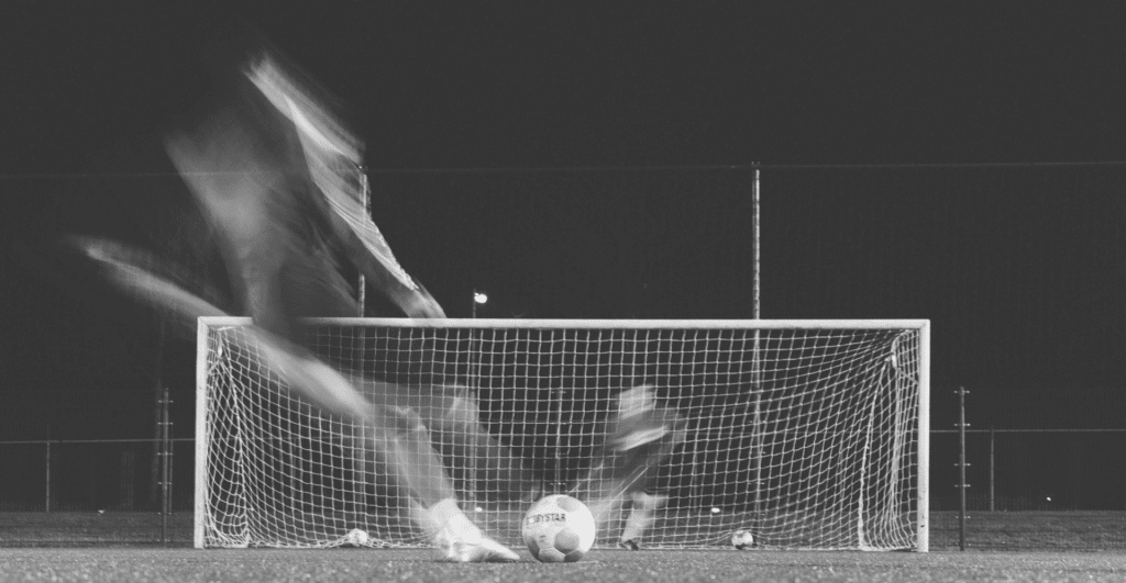 This image of a striker scoring a goal in the dark highlights the topic of this blog: online protection in football and beyond.
