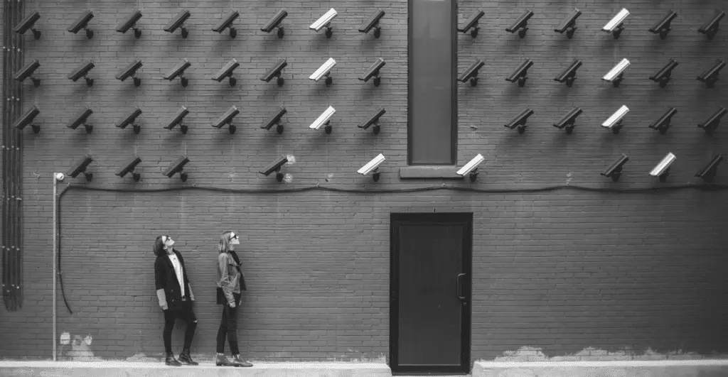 This image of two people standing in front of a wall of security cameras highlights our discussion topic: An interview about brand protection with EBRAND's US MD Andrew Brodsky.