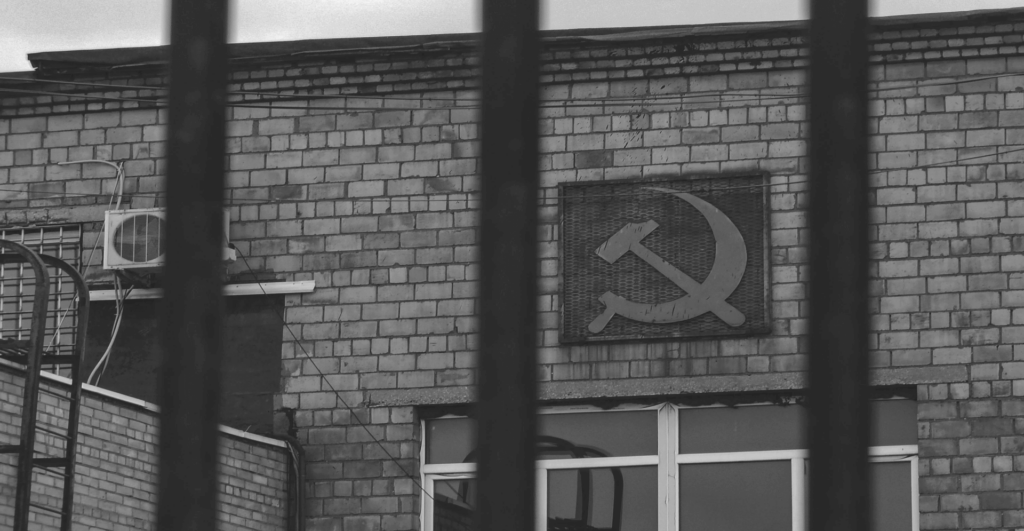 This image of the Soviet hammer and sickle on a building behind bars highlights the global dangers of our discussion topic: the top ten most dangerous ccTLDs (country code top level domain extensions).