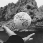 This image of a globe in someone's hand over a precipice highlights the global dangers of our discussion topic: the top ten most dangerous ccTLDs (country code top level domain extensions).