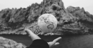 This image of a globe in someone's hand over a precipice highlights the global dangers of our discussion topic: the top ten most dangerous ccTLDs (country code top level domain extensions).