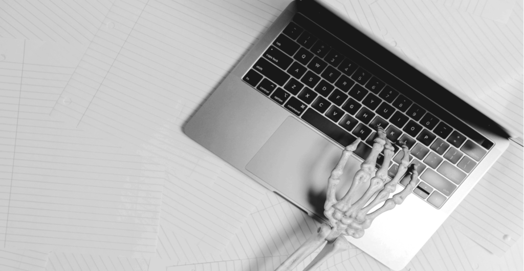 This image of a skeletal hand typing at a laptop illustrates this guide's discussion topic: the pitfalls of brand protection.