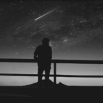 This image of a person looking over a viewpoint bannister at a sky full of stars highlights the complexity of domain management, with a specific focus on EBRAND's COSMOS domain platform.