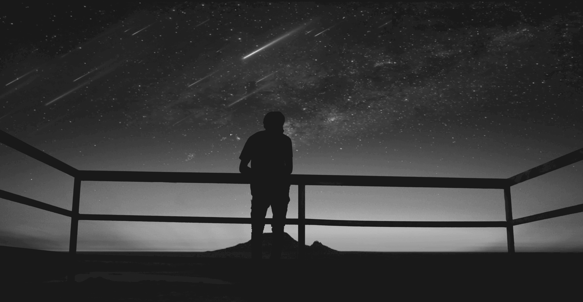 This image of a person looking over a viewpoint bannister at a sky full of stars highlights the complexity of domain management, with a specific focus on EBRAND's COSMOS domain platform.