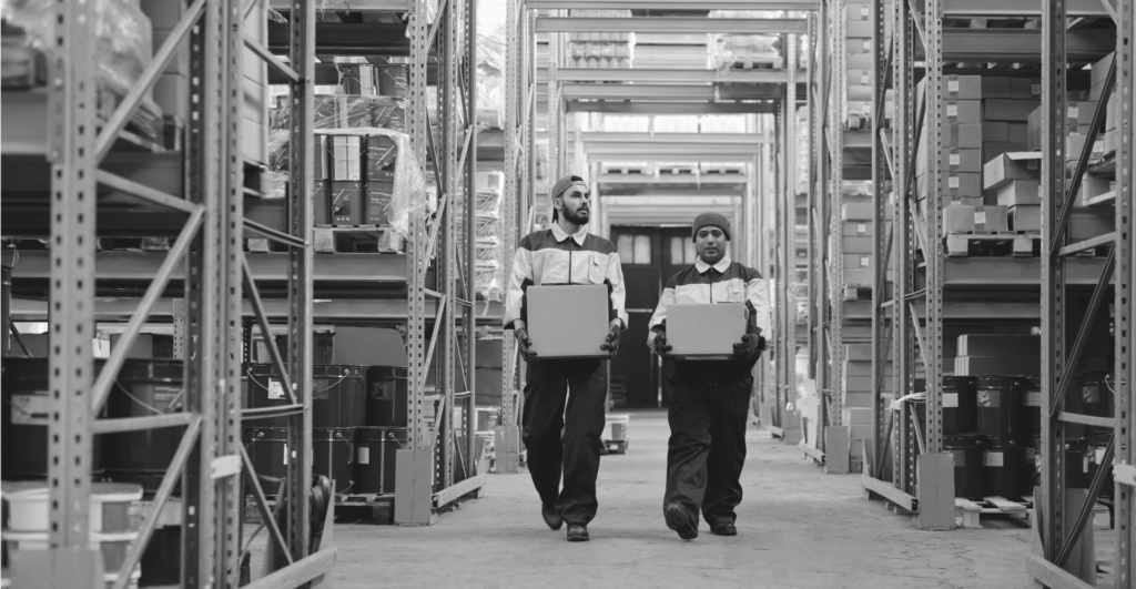 This image of two warehouse workers carrying different boxes highlights this piece's discussion topic: The importance of a test purchase for Online Brand Protection.