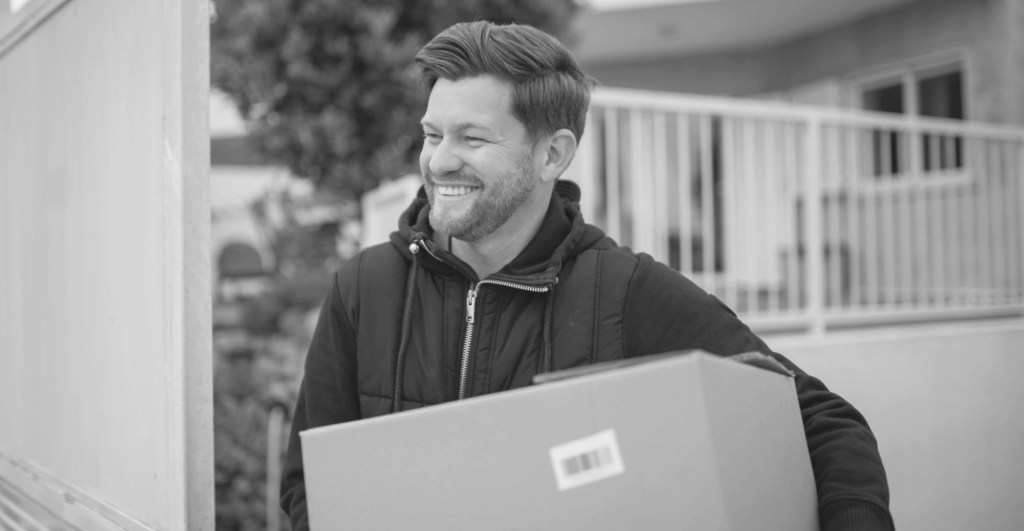 This image of a smiling man holding a box highlights this piece's discussion topic: The importance of a test purchase for Online Brand Protection.