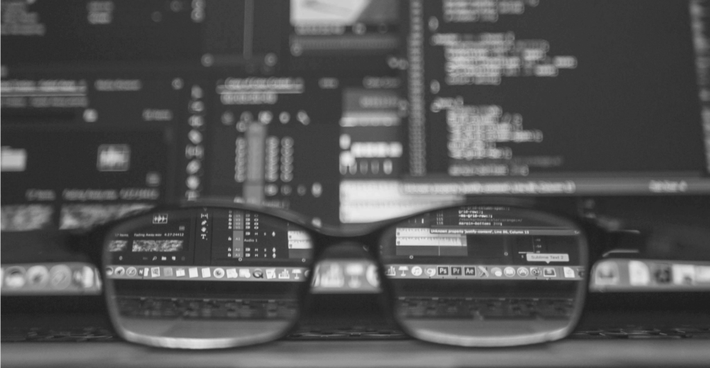 This image of a pair of spectacles in front a computer screen illustrates our discussion topic: WIPO domain reports, and what they mean for an organization's domain strategy in 2025 and beyond/