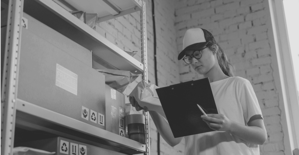 This image of a logistics worker checking parcels with a clip board highlights the crux of this article: Investigating the role of offline activity in grey markets and global counterfeiting, and how offline investigations support comprehensive anti counterfeiting and online brand protection efforts.