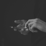 This image of someone on their phone highlights the discussion topic of online banking, and how organizations should chase banking cyberattacker away from their online landscapes with digital risk protection.