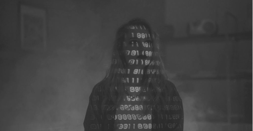 This image of a girl with binary 1s and 0s projected onto her body highlights the discussion topic of online banking, and how organizations should chase banking cyberattacker away from their online landscapes with digital risk protection.