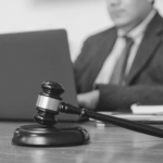 This image of a man at a desk with a computer and a gavel illustrates our discussion topic: domain names vs. trademarks