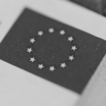 This image of the EU flag on a Euro note illustrates our discussion topic: NIS2, the changes for your organization, and the relevance of Corporate Domain Management.