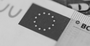 This image of the EU flag on a Euro note illustrates our discussion topic: NIS2, the changes for your organization, and the relevance of Corporate Domain Management.
