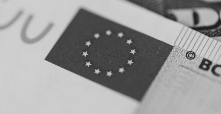 This image of the EU flag on a Euro note illustrates our discussion topic: NIS2, the changes for your organization, and the relevance of Corporate Domain Management.