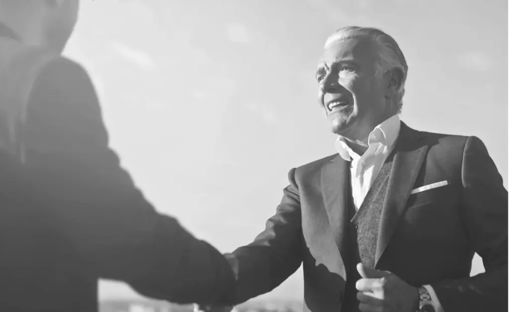 This image of a suited man shaking hands illustrates our discussion topic about CEO fraud.