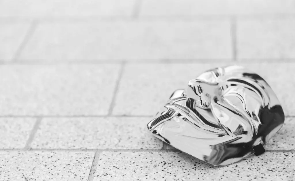 This image of a mask on the ground illustrates our discussion topic about digital risk protection top tips.