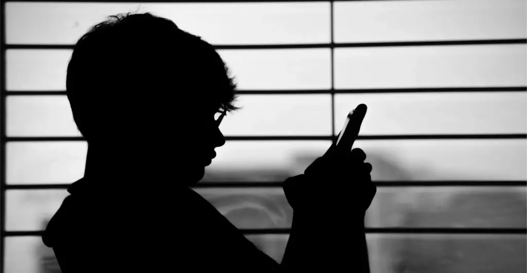 This image of a man on his phone illustrates our discussion topic: scams on Linktree and how to fight back.