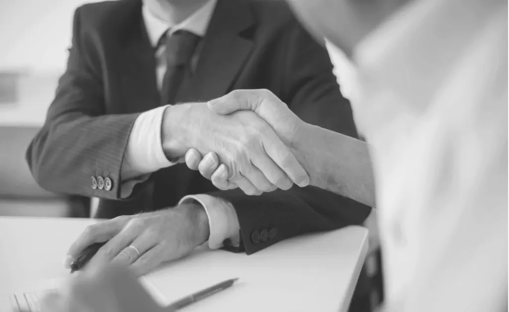 This image of a two colleagues shaking hands together illustrates our discussion topic about phishing as a service.