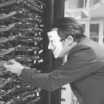 This image of a masked man at a server bank illustrates our discussion topic about phishing as a service.