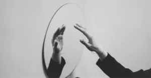 This image of a hand reaching towards its reflection in the mirror illustrates our discussion topic: Dupes, counterfeits, and what brands can do about them.