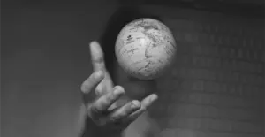 This image of a hand grasping a globe illustrates our discussion topic: DDoS attacks, downtimes, and how the right DNS service helps teams fight back.
