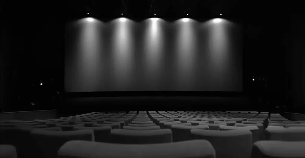 This image of spotlights on a movie theatre illustrates our discussion topic: Celebrity impersonations, CEO fraud, and identity protection.